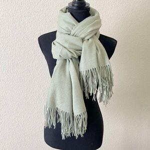 The soft warm pistachio-colored scarve made of a mixture of acrylic and cashmere